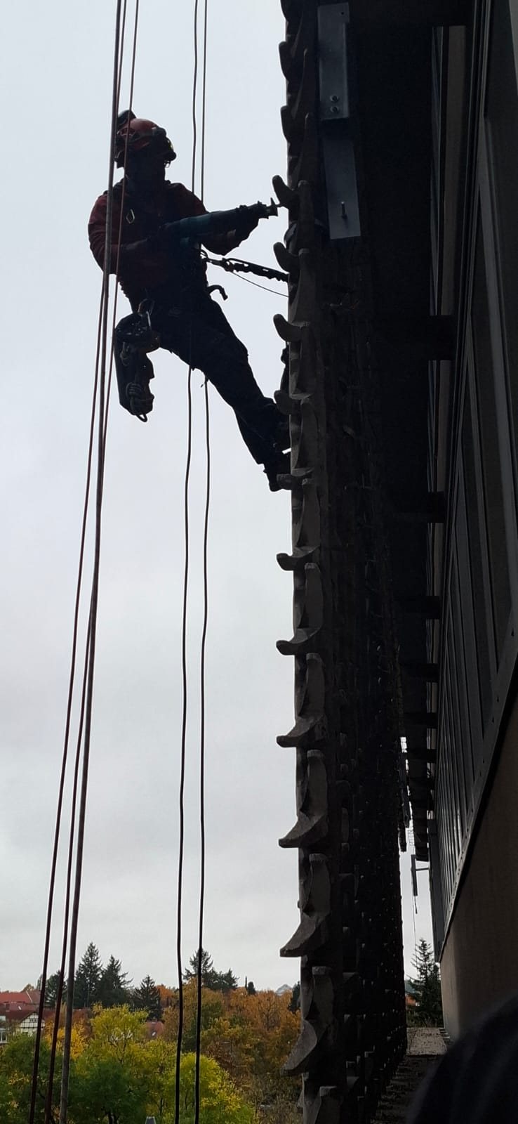 Montage- und Bohrarbeiten an einer Fassade am Seil